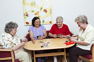 Vier Seniorinnen beim gemeinsamen Kartenspiel